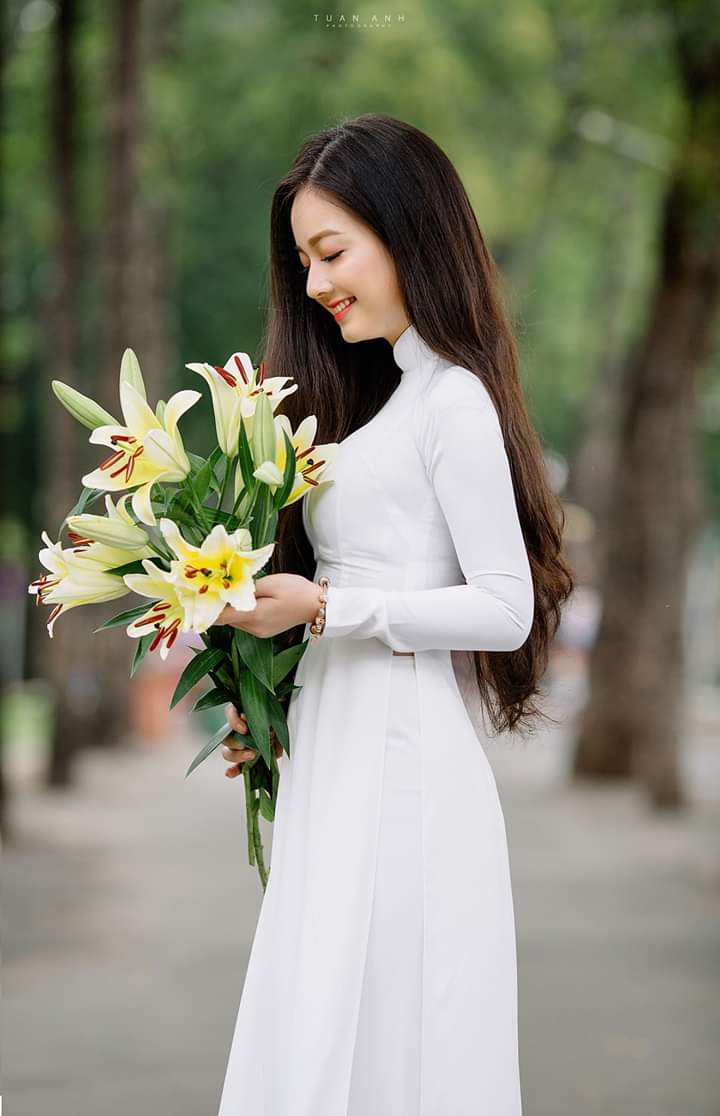 Tạo dáng với áo dài bằng cách nhìn vào hoa (Aphoto) Tạo dáng với áo dài bằng cách nhìn vào hoa (Aphoto)